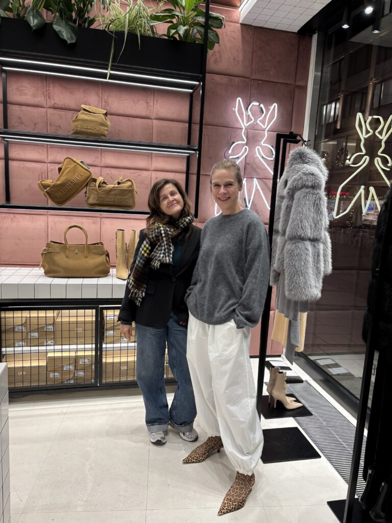 Personal Stylistin mit Kundin im Patrizia Pepe Store in der Theatinerstraße in München zwischen Taschen, Schuhen und modernen Fashion-Looks.