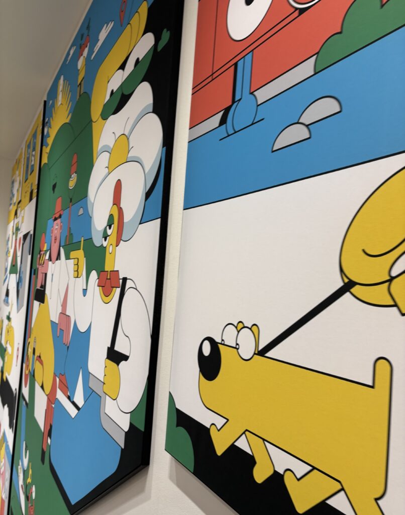 Buntes Wandbild des Künstlers Sebastian Schwamm im Uniqlo Store mit grafischen Figuren und illustrativem Design.